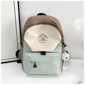 Detalle de una mochila de estilo japonés con bloques de color, logo y colgante de felpa