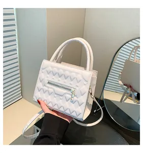 Dettaglio borsa a mano bianca in pelle PU trapuntata con zip dorata e manico curvo