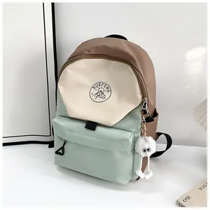 Detalle de mochila de nailon multicolor con tela impermeable y adorno de peluche