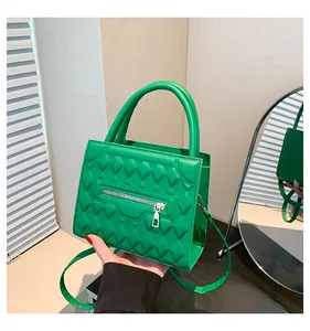 Dettaglio della borsa verde in pelle PU trapuntata con motivo a zig-zag e cerniera