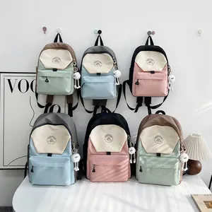 Mochila escolar estilo japonés con diseño de bloques de color y lindo colgante suave