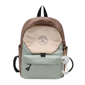 Mochila escolar de tres colores con colgante de peluche y logotipo de montaña frontal