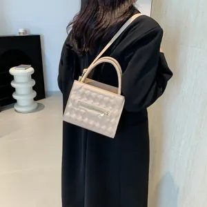 Borsa a tracolla quadrata beige minimalista con texture geometrica a rilievo e oro