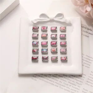 Detailansicht von 20 rosa italienischen Modul-Charms auf einem weißen Keramiktablett