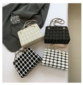 Flat lay of four tweed chain shoulder bags in various colors on a minimalist desktop