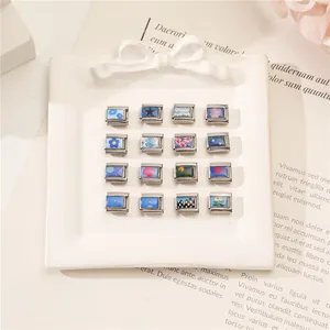 Close-up of DIY Italian charms set with floral and star patterns on silver steel blocks