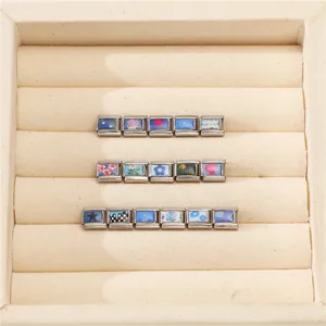 Detailed close-up of colorful DIY Italian charms with floral and mosaic patterns