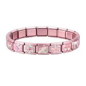 Detailed macro of modular pink charm bracelet with stainless steel links and cute icons
