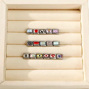 Detailed view of Italian charm links with assorted butterfly, flower, and evil eye icons