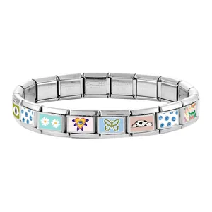 Close-up of modular Italian bracelet links with colorful daisy and butterfly patterns
