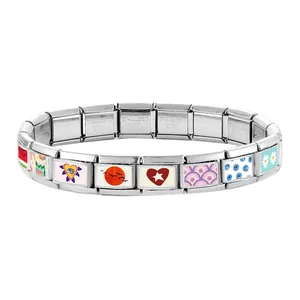 Detail of modular Italian charms bracelet with colorful enamel icons and steel stamps