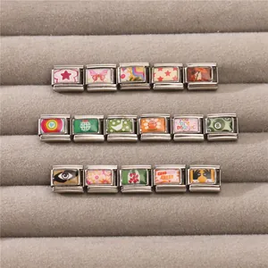 Dettaglio macro di charm italiani modulari con motivi vintage su vassoio per gioielli