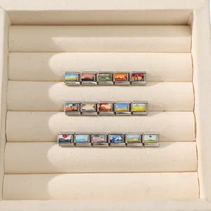 Macro view of modular Italian charm links with miniature landscape paintings in velvet box