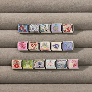 Macro detail of various stainless steel Italian charms with colorful enamel designs