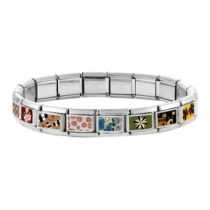 Macro detail of Italian charm bracelet links showing stainless steel hallmark and enamel art