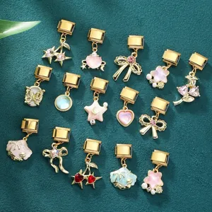 Détail de charms modulables italiens avec motifs cerises et étoiles dorés et roses