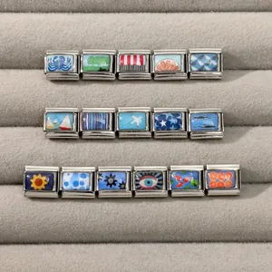Macro view of 16 assorted Italian charm modules with various colorful patterns on a tray