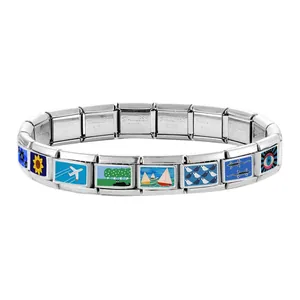 Close-up of modular stainless steel bracelet links with colorful enamel charm patterns
