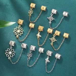 Detailed macro of gold and silver Italian charm safety chains with floral and butterfly motifs