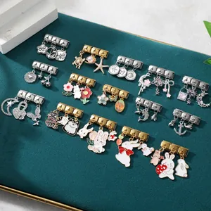 Detailed view of DIY Italian charm pendants in gold and silver with enamel animal motifs