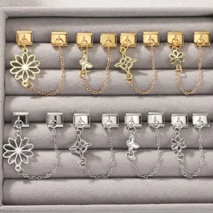 Detail of gold and silver Italian link charms with butterfly and flower dangles in a box