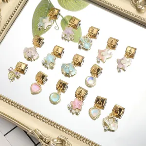 Macro shot of gold Italian charms with shell, star and heart motifs for modular bracelets