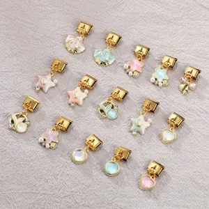 Macro shot of 13 gold-plated Italian modular charms with shell and star ocean themes