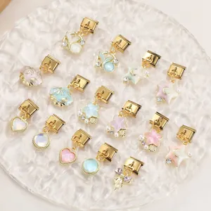 Detailed Italian charm links with colorful enamel shells and stars on a glass tray