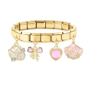Detail of a modular gold stainless steel bracelet with seashell and heart charms