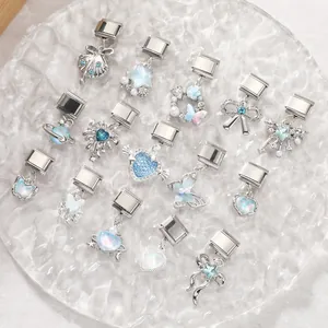 Dettaglio charm blu per bracciali modulari su un vassoio di vetro con texture elegante