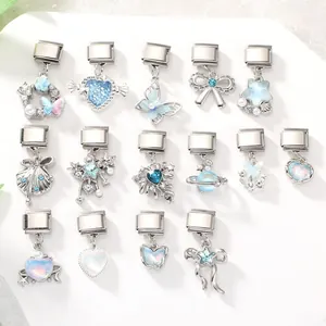 Dettaglio macro di charm modulari italiani con cristalli blu e motivi a farfalla