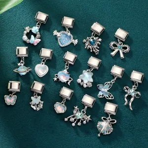 Dettaglio di charm italiani con opale, strass blu e design a forma di farfalla