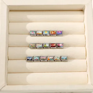 Dettaglio di 16 charms italiani modulari con illustrazioni di paesaggi colorati su acciaio