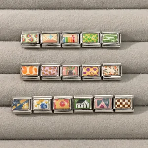 Detailansicht italienischer Charm-Links mit Blumen- und Hausmustern auf einem Schmucktablett