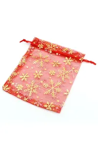 Detalle de bolsa de regalo en organza roja con copos de nieve dorados y cordón de seda