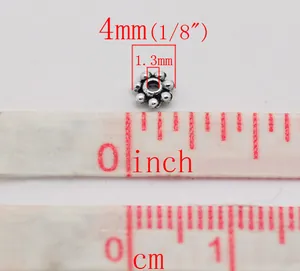 Vista macro della perla distanziatrice a margherita da 4mm in argento antico per gioielli