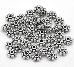 Dettaglio di perline distanziatrici a fiore in argento satinato per gioielli DIY