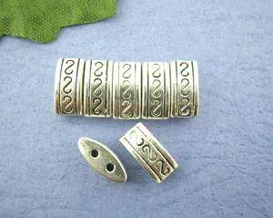 Dettaglio di perline distanziatrici in metallo argento con motivi e doppi fori paralleli