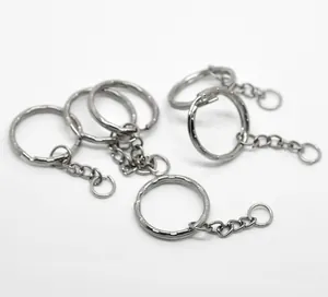 Close-up of silver metal key rings with chain links and jump rings on white surface
