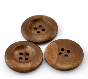 Detalle macro de tres botones de madera redondos marrones de cuatro agujeros con veta