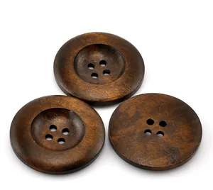 Detalle de tres botones de madera marrón oscuro con cuatro agujeros y textura de grano natural