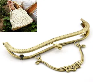 Detalle del marco de bronce para bolso con grabado floral vintage y cierre de asa
