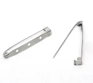 Detail view of two silver safety pins with a three-hole base for DIY brooch making