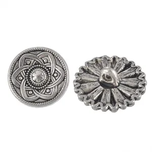 Macro detail of vintage silver metal shank buttons with embossed floral patterns