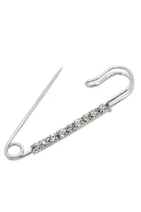 Close-up of silver-tone pin brooch with ten aligned clear crystals on polished metal