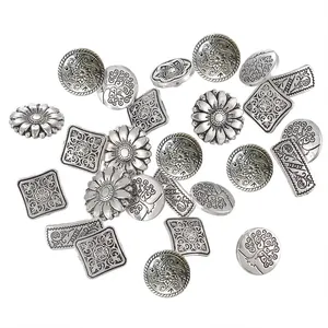 Close-up of assorted vintage silver metal buttons with floral and geometric patterns