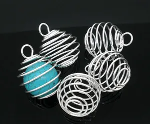 Detailed macro view of silver spiral bead cages showing one with a turquoise bead