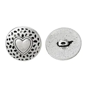 Macro detail of retro silver heart pattern metal button showing front and shank back