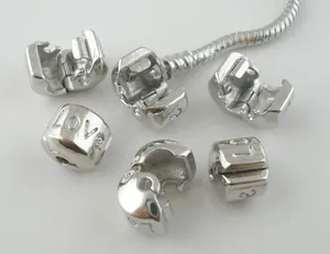 Dettaglio macro di clip in argento incise LOVE per catene a serpente lucidate