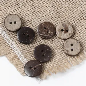 Macro view of assorted brown coconut shell buttons with two holes on rustic burlap
